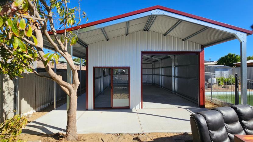 Cream coloured steel shed with red trim, sliding glass door, and open roller door